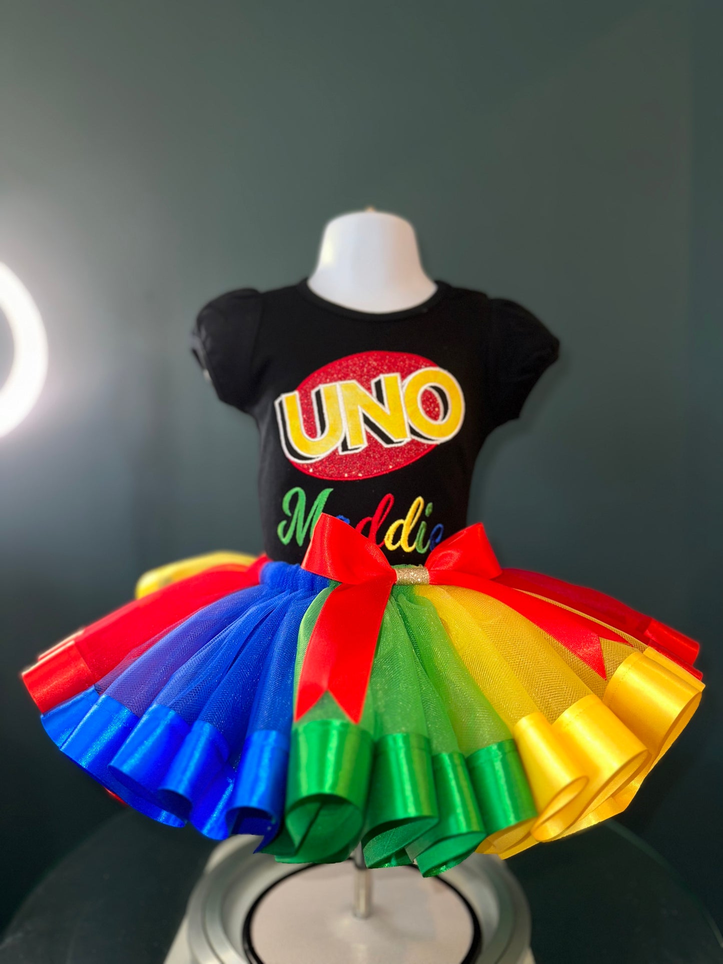uno theme birthday outfit. personalized embroidery. black puff sleeve shirt and matching multi colored tulle skirt with waist bow
