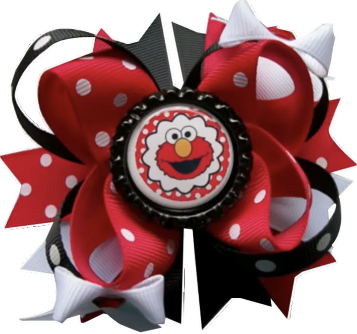 A decorative hair bow featuring red, black, and white polka-dot ribbon loops with a central round button showing Elmo&