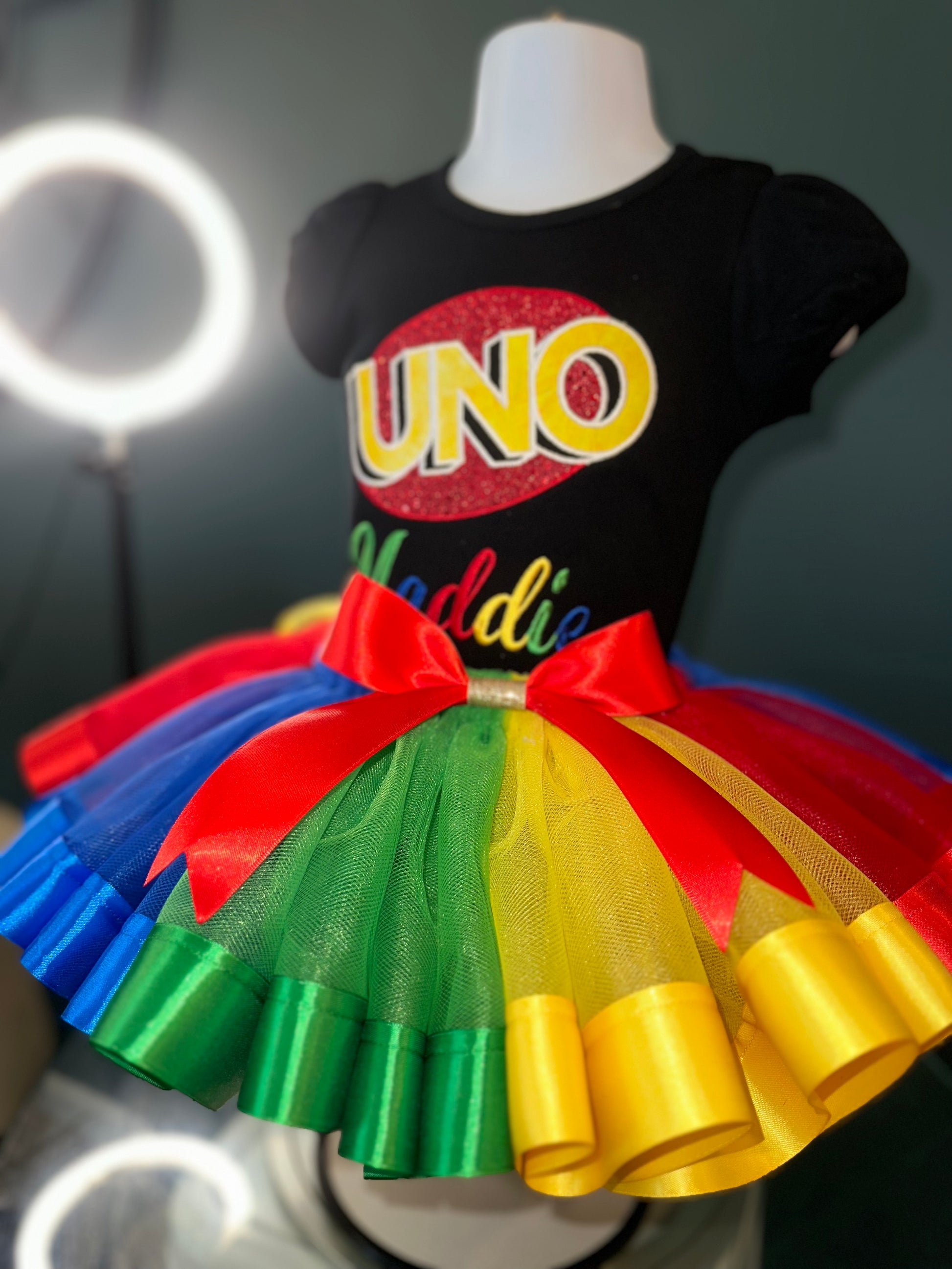 uno theme birthday outfit. personalized embroidery. black puff sleeve shirt and matching multi colored tulle skirt with waist bow