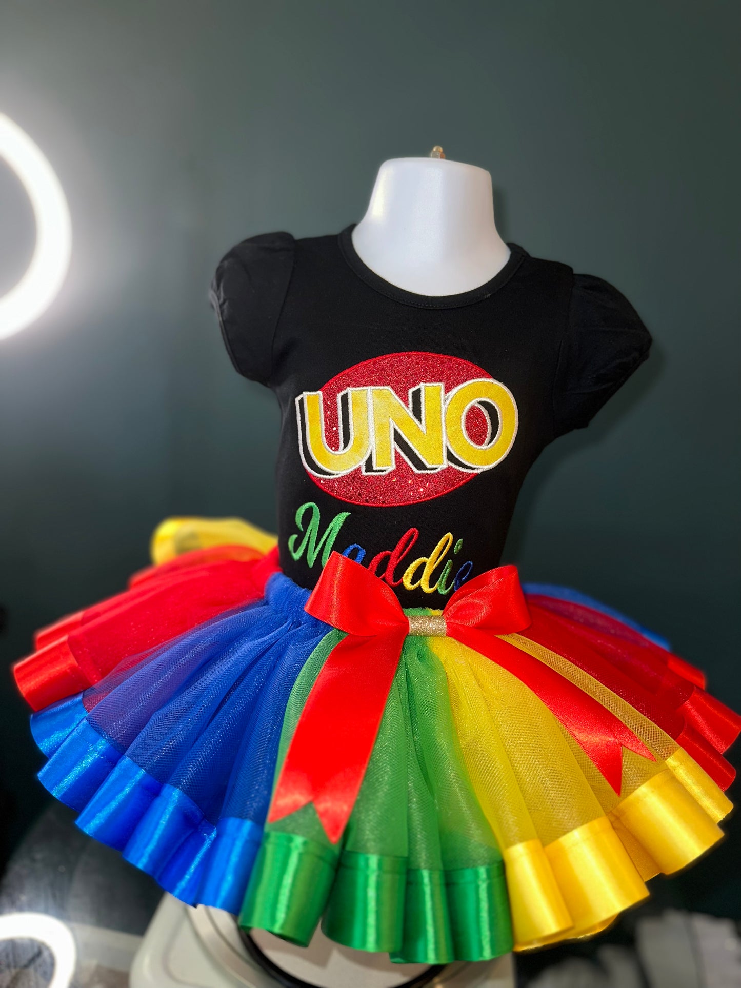 uno theme birthday outfit. personalized embroidery. black puff sleeve shirt and matching multi colored tulle skirt with waist bow