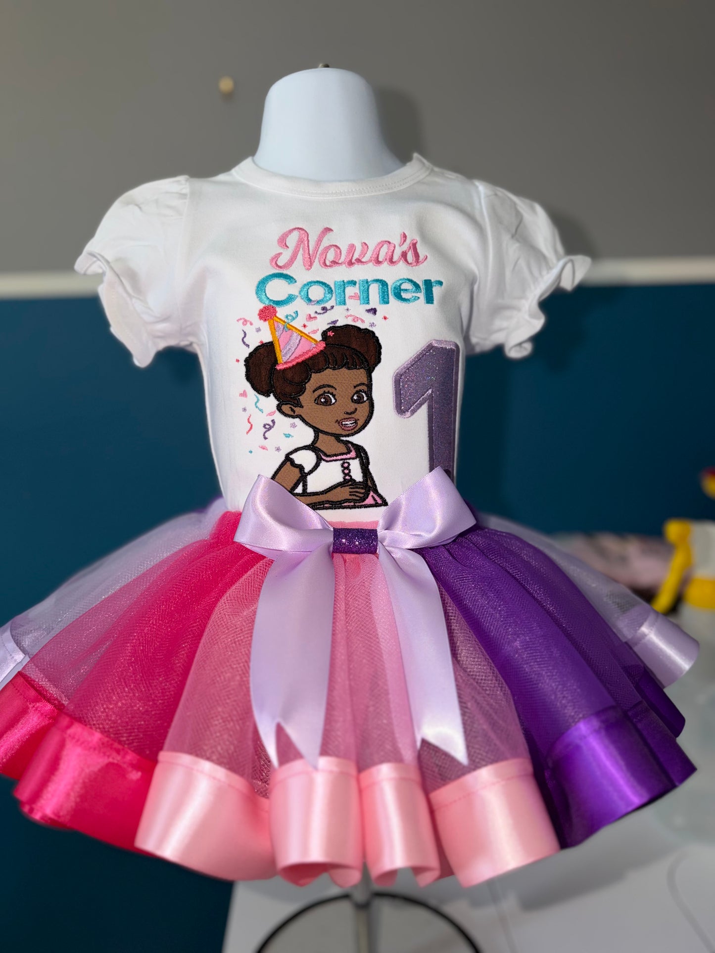 Children's outfit with a white shirt and colorful tutu on a mannequin.