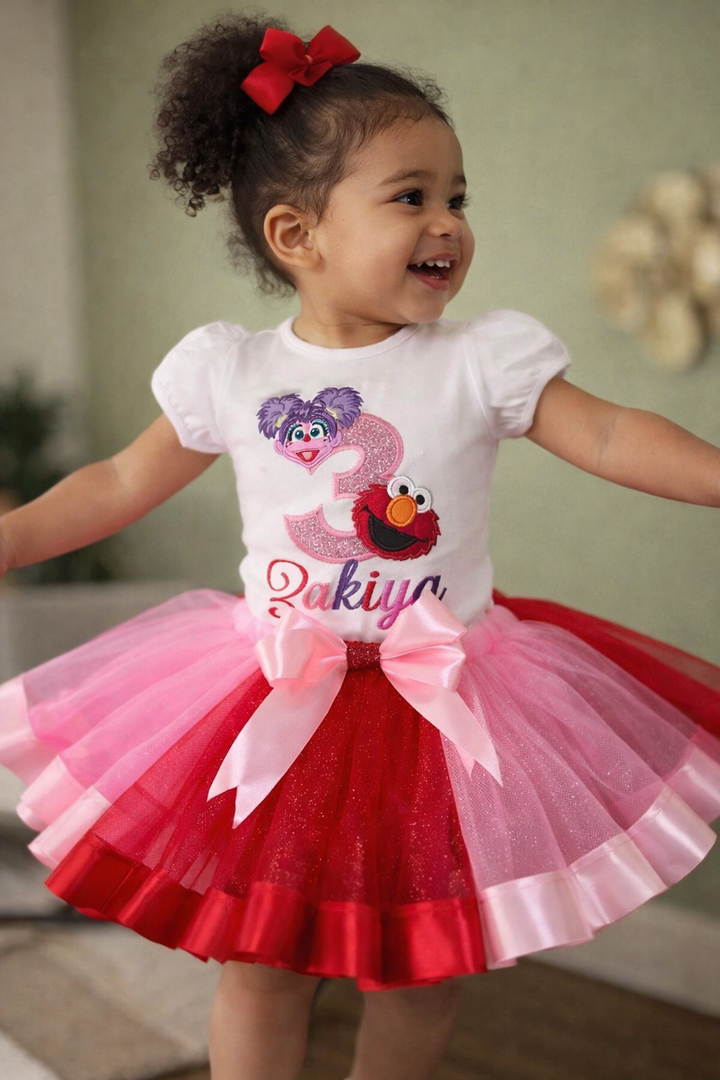 Child wearing a festive outfit with a tutu skirt and birthday-themed shirt.