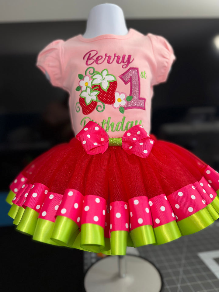 Pink and red birthday dress with strawberry design on a mannequin.